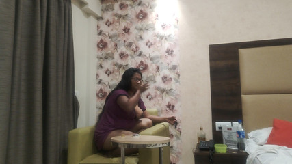 सुडौल भारतीय लड़की कुर्सी पर प्रति बिल्ली के साथ खेलती है