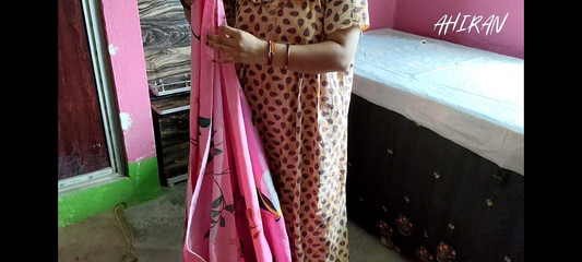 भारतीय लड़की अपने शयनकक्ष में कपड़े तह कर रही है