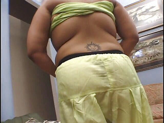 टैटू वाला बड़ा भारतीय त्रिगुट में एक मुर्गा की सवारी करता है